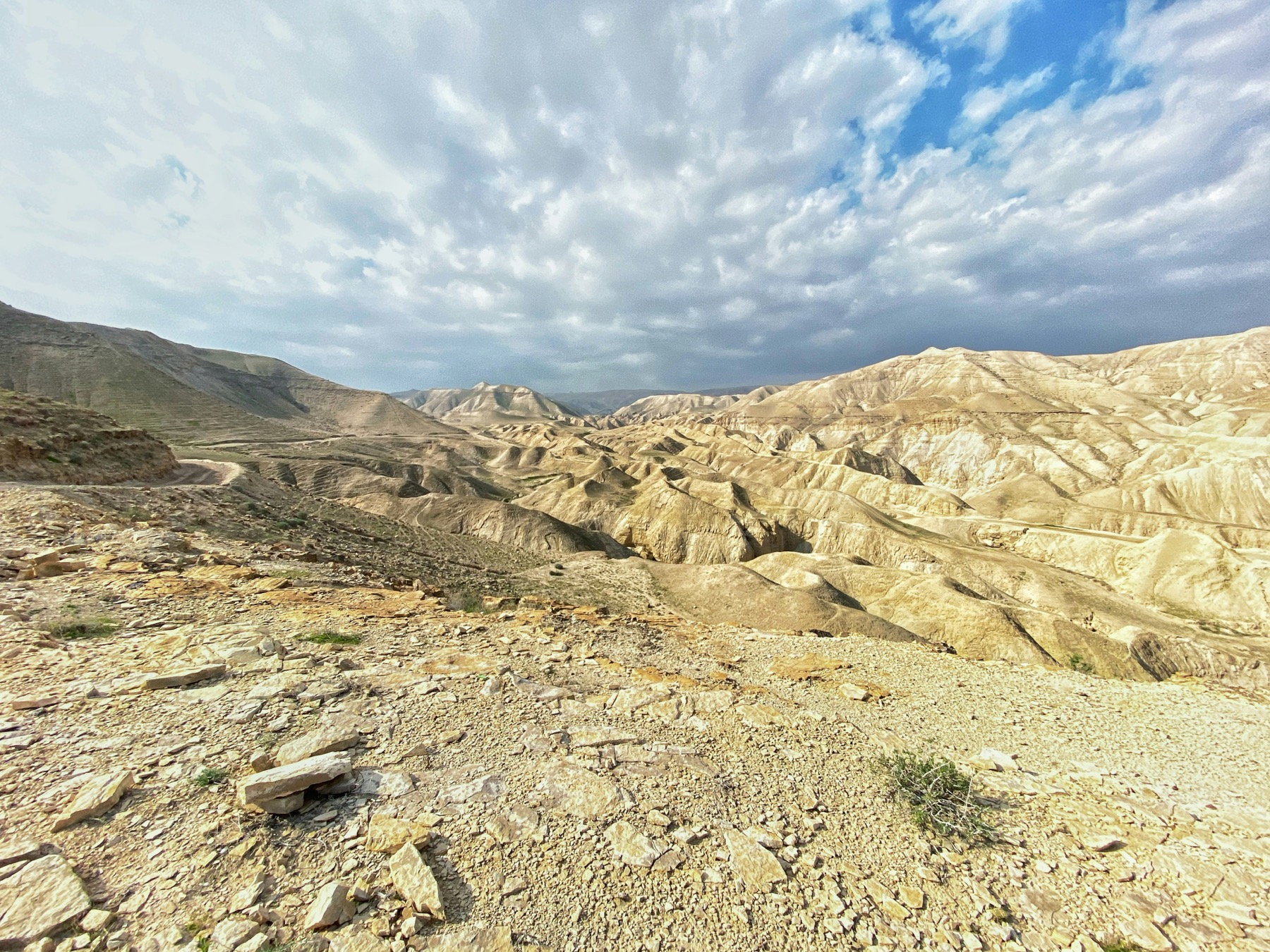 A winding path through rocky desert hills beneath an open sky.